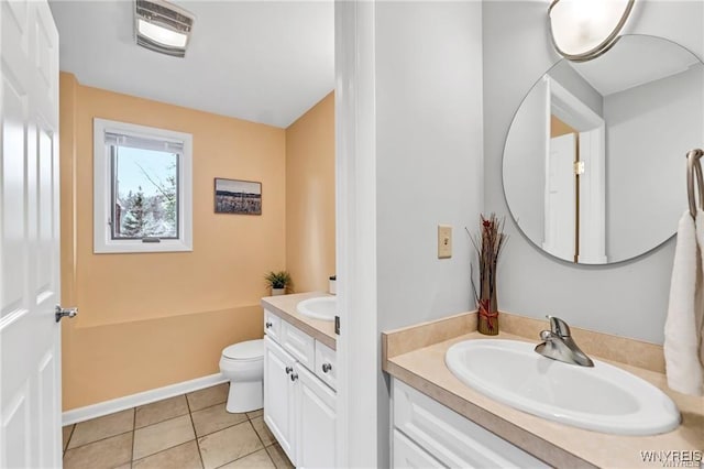 bathroom with toilet, baseboards, vanity, and tile patterned floors