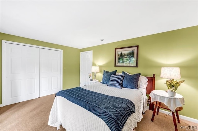 carpeted bedroom with baseboards and a closet