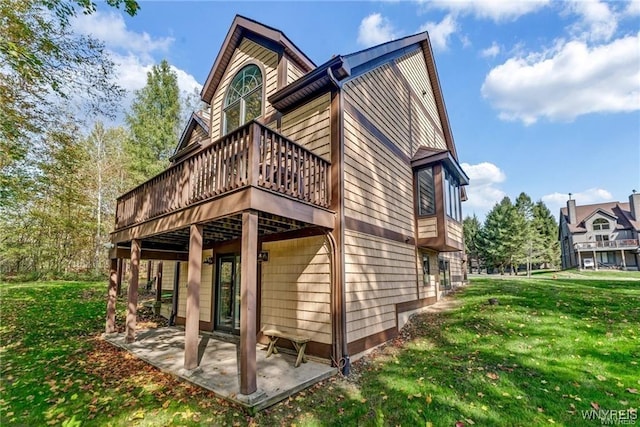 rear view of property with a patio area, a lawn, and a deck