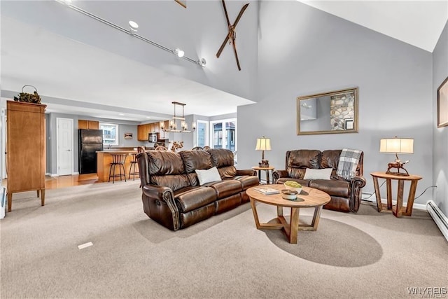 living room with an inviting chandelier, baseboards, high vaulted ceiling, and light colored carpet