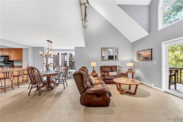 living area featuring light carpet, baseboard heating, a towering ceiling, and an inviting chandelier