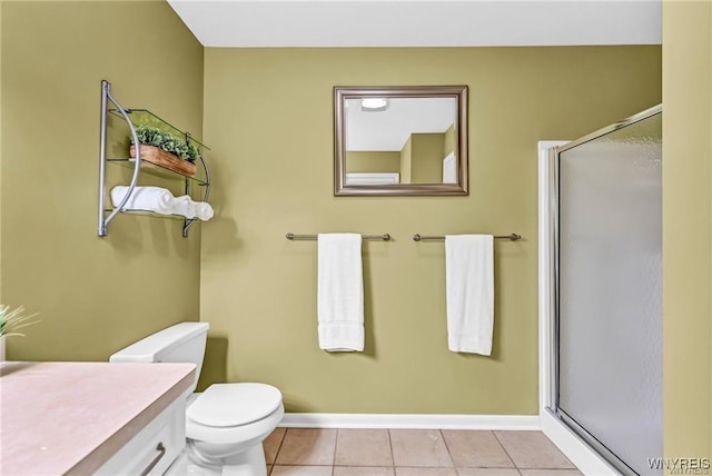 full bath with baseboards, tile patterned flooring, toilet, and a shower stall