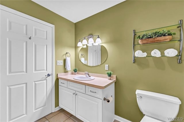 half bath featuring tile patterned flooring, vanity, and toilet