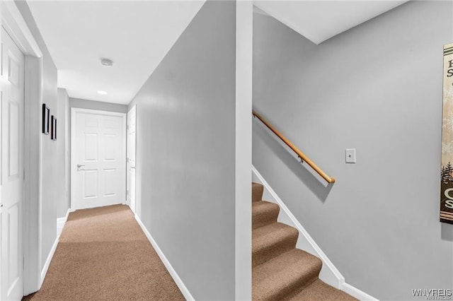 hall with carpet flooring, baseboards, and stairs