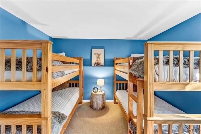 carpeted bedroom with vaulted ceiling and baseboards