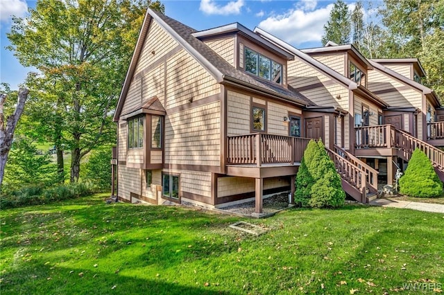 view of front of house with stairs, a front lawn, and a wooden deck