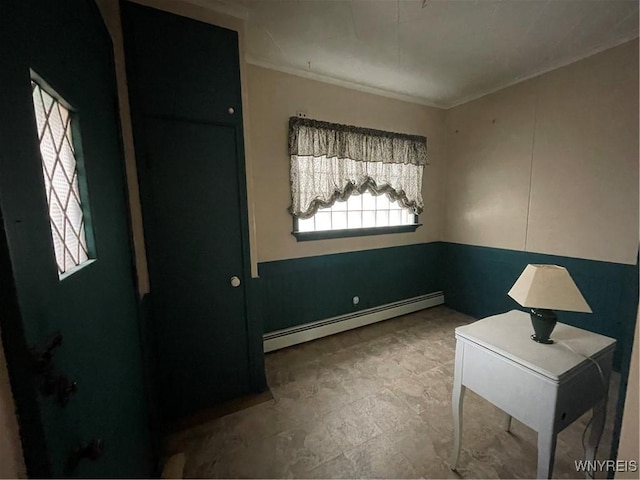 interior space with ornamental molding and a baseboard heating unit