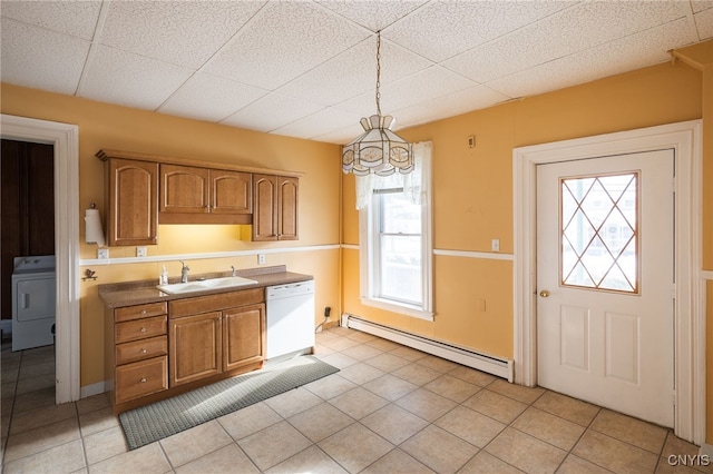 kitchen with sink, baseboard heating, white dishwasher, decorative light fixtures, and washer / dryer