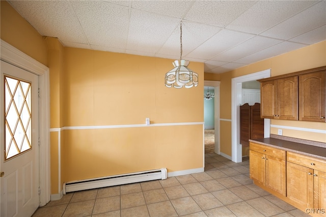 kitchen featuring hanging light fixtures, a drop ceiling, baseboard heating, and a notable chandelier