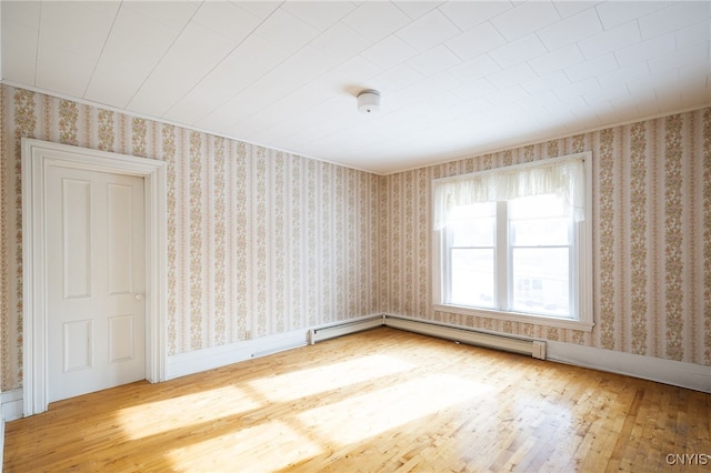 spare room with hardwood / wood-style flooring and a baseboard radiator