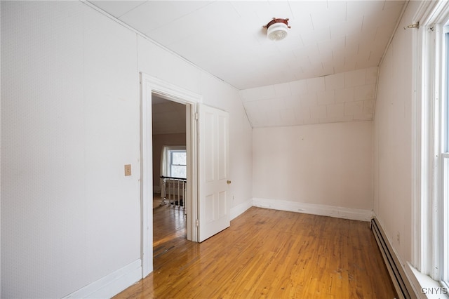 bonus room with light hardwood / wood-style flooring, a baseboard radiator, and vaulted ceiling