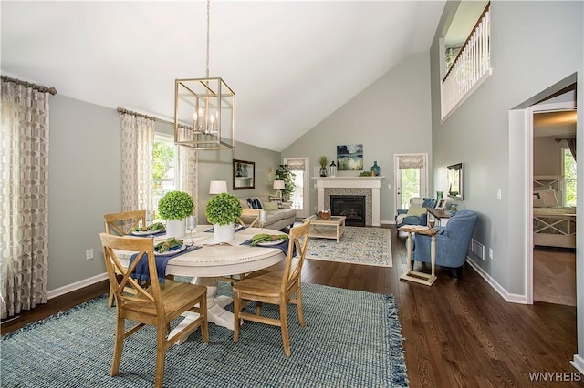 dining area featuring an inviting chandelier, dark wood-type flooring, and high vaulted ceiling