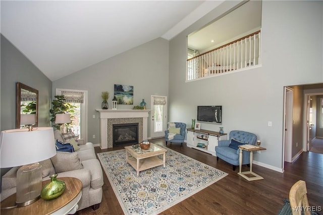 living room featuring dark hardwood / wood-style flooring, a tiled fireplace, and high vaulted ceiling