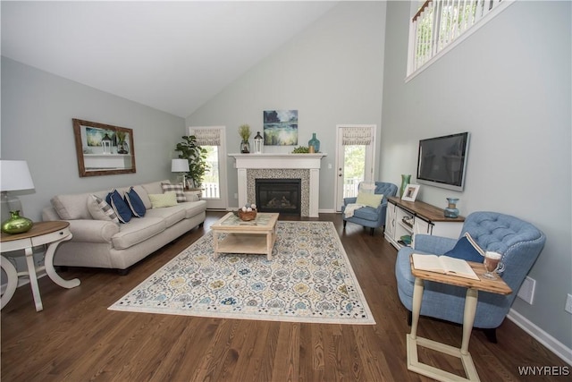 living room featuring dark wood-type flooring, a wealth of natural light, and a tile fireplace