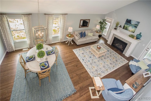 living room with a healthy amount of sunlight, dark hardwood / wood-style flooring, and a chandelier