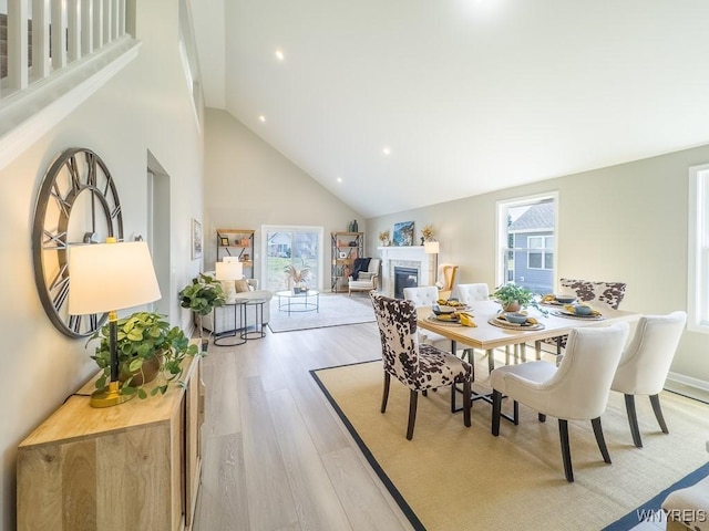6668 Curtis Ct, Lockport-Town, NY 14094 - dining room with high vaulted ceiling, light wood finished floors, a glass covered fireplace, and recessed lighting