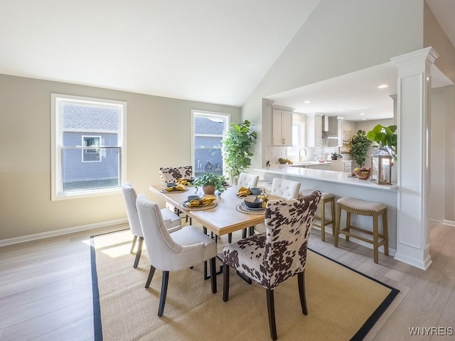 6668 Curtis Ct, Lockport-Town, NY 14094 - dining area with light wood-type flooring, baseboards, ornate columns, and high vaulted ceiling