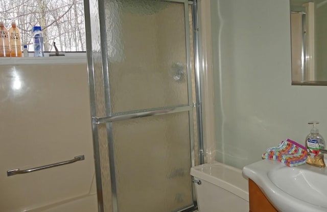 bathroom with toilet, vanity, and walk in shower