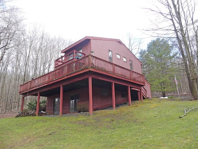 back of property with a wooden deck and a yard