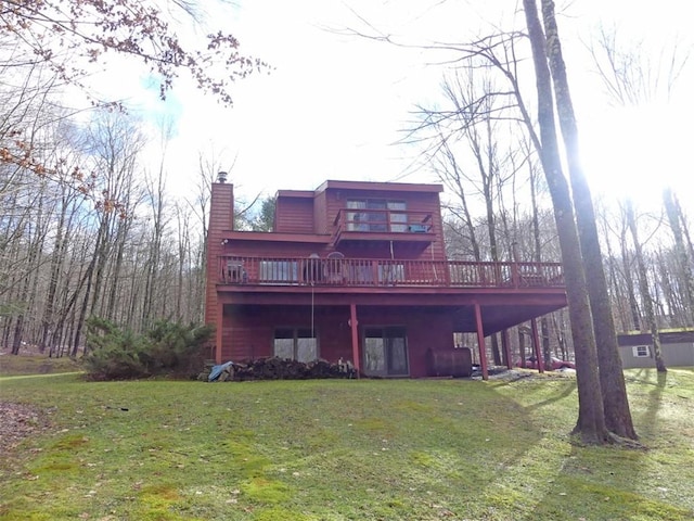 back of property featuring a wooden deck and a yard