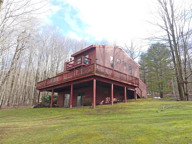 rear view of house featuring a deck and a yard