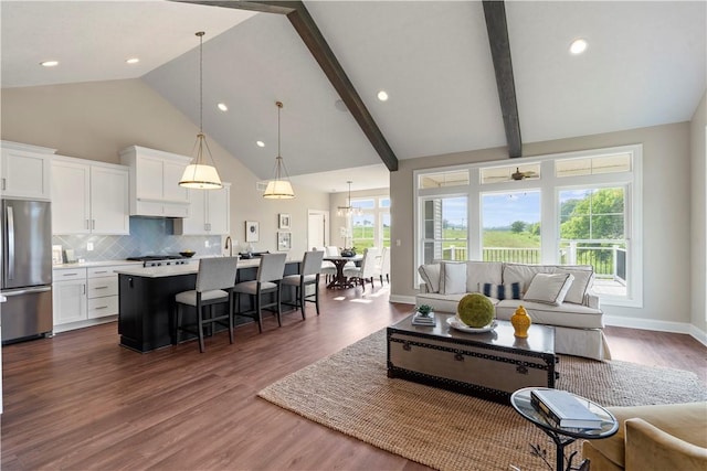 living room featuring beamed ceiling, dark hardwood / wood-style floors, ceiling fan, and high vaulted ceiling