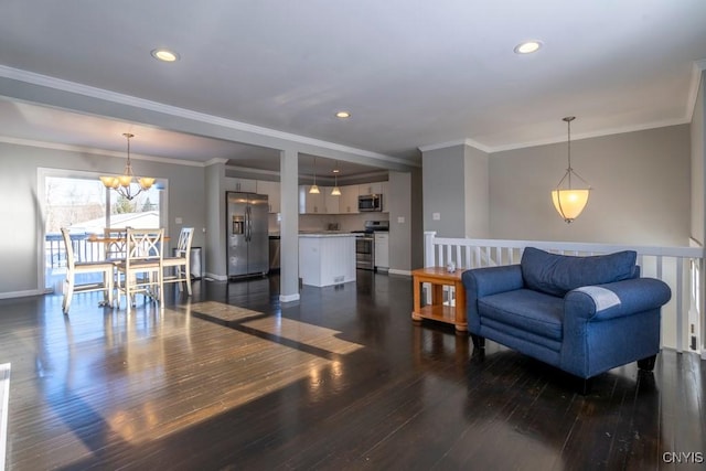 living room with dark hardwood / wood-style flooring, an inviting chandelier, and ornamental molding