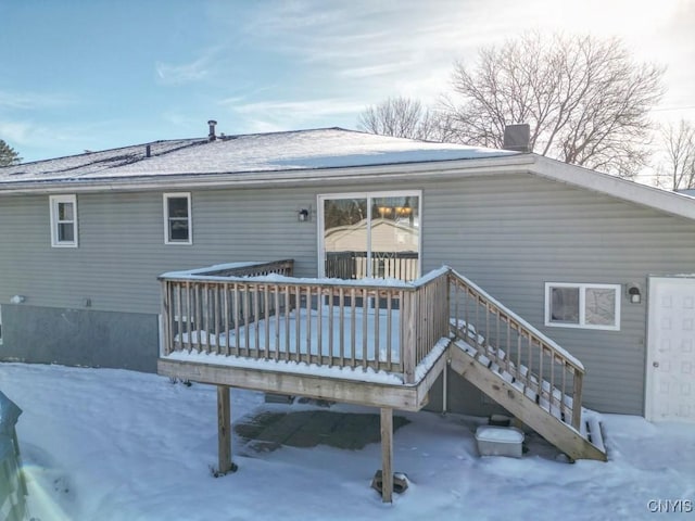 snow covered rear of property featuring a wooden deck