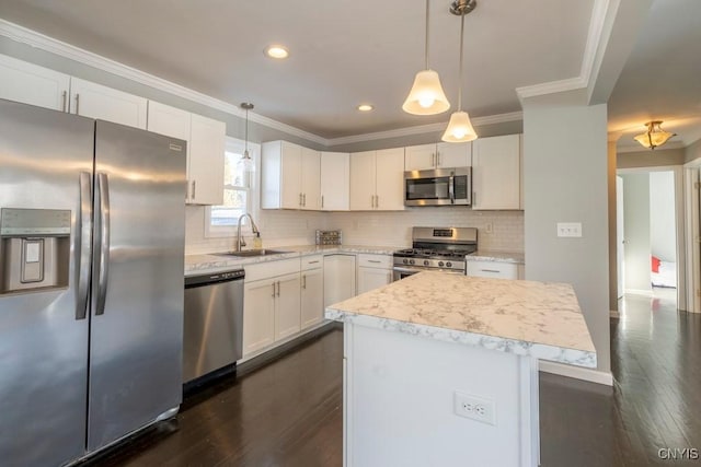 kitchen featuring pendant lighting, white cabinets, sink, a kitchen island, and stainless steel appliances