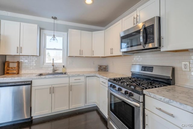 kitchen with light stone countertops, sink, pendant lighting, white cabinets, and appliances with stainless steel finishes