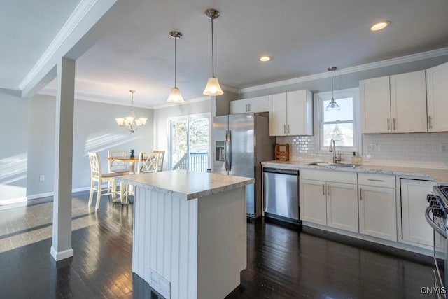 kitchen with white cabinetry, sink, backsplash, decorative light fixtures, and appliances with stainless steel finishes