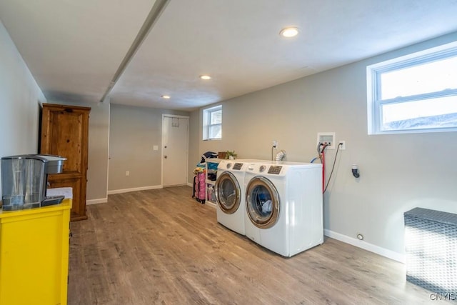 washroom with washing machine and dryer and light wood-type flooring