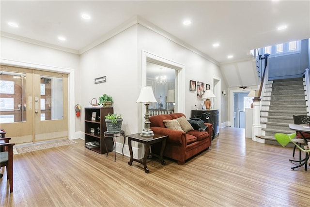 living room featuring french doors, ornamental molding, light hardwood / wood-style flooring, a chandelier, and lofted ceiling