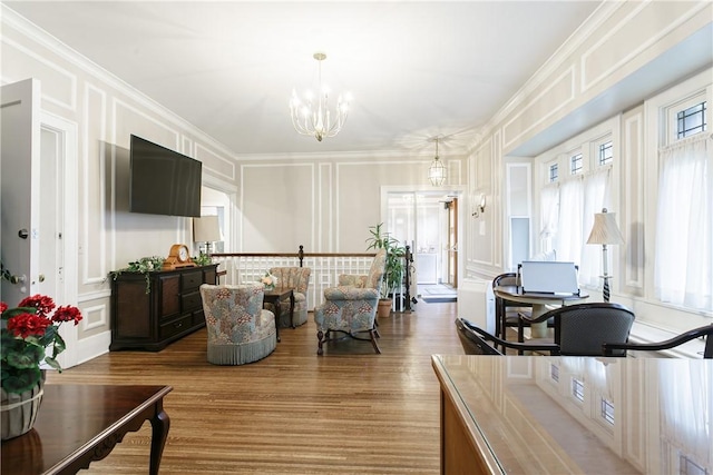 living room featuring hardwood / wood-style floors, an inviting chandelier, and ornamental molding