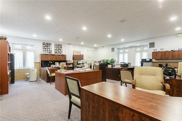 carpeted office featuring a textured ceiling