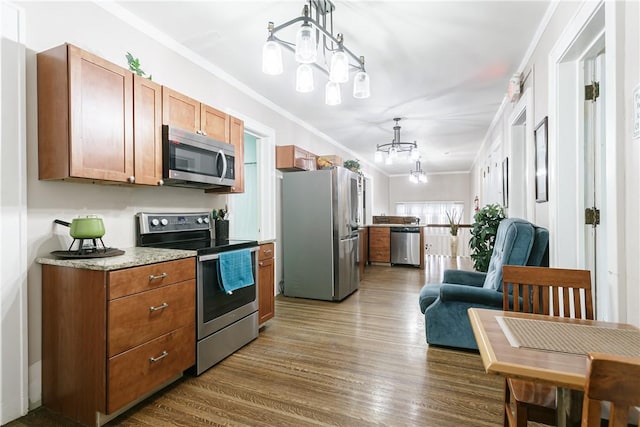 kitchen with crown molding, stainless steel appliances, decorative light fixtures, and an inviting chandelier