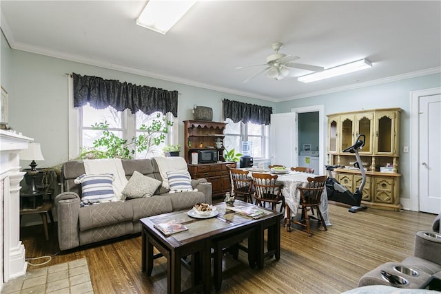 living room featuring washer / dryer, a wealth of natural light, ceiling fan, and ornamental molding