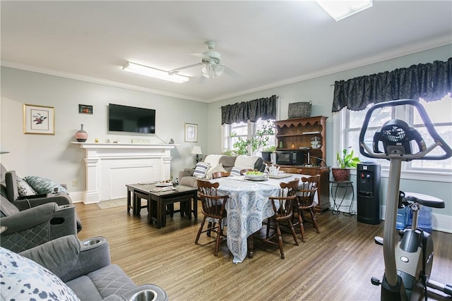 living room featuring hardwood / wood-style flooring, ceiling fan, and crown molding