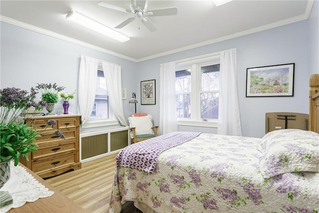 bedroom featuring ceiling fan, radiator heating unit, wood-type flooring, and ornamental molding