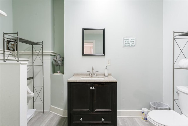 bathroom featuring hardwood / wood-style floors, vanity, and toilet