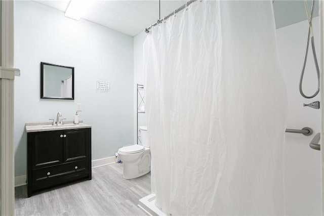 bathroom featuring hardwood / wood-style floors, vanity, a shower with shower curtain, and toilet