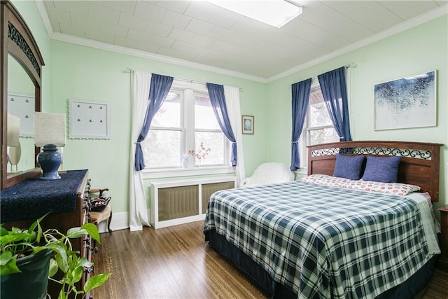 bedroom featuring crown molding and dark hardwood / wood-style floors