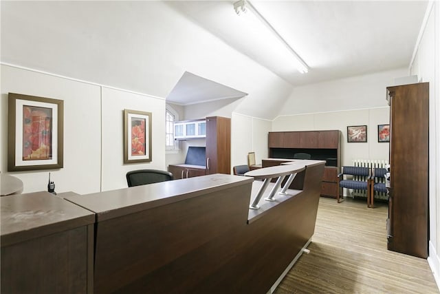 kitchen featuring light wood-type flooring, radiator, and lofted ceiling