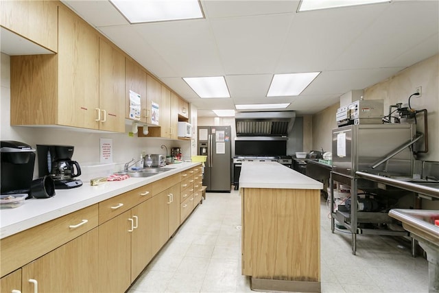 kitchen featuring sink, a kitchen island, a drop ceiling, and stainless steel refrigerator with ice dispenser