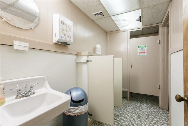 bathroom with a drop ceiling and sink