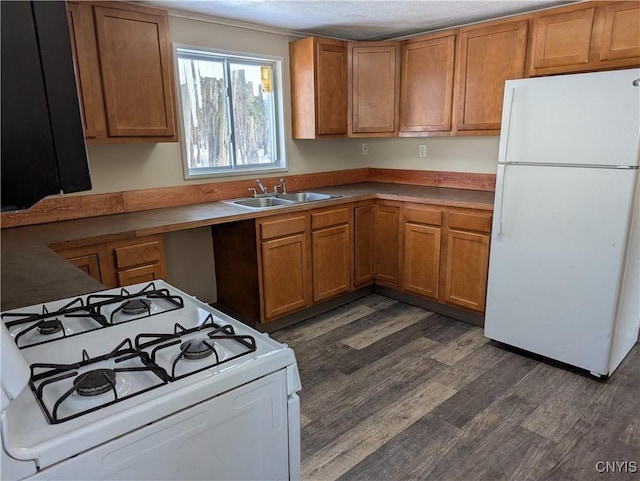 kitchen featuring a textured ceiling, sink, dark wood-type flooring, and white appliances