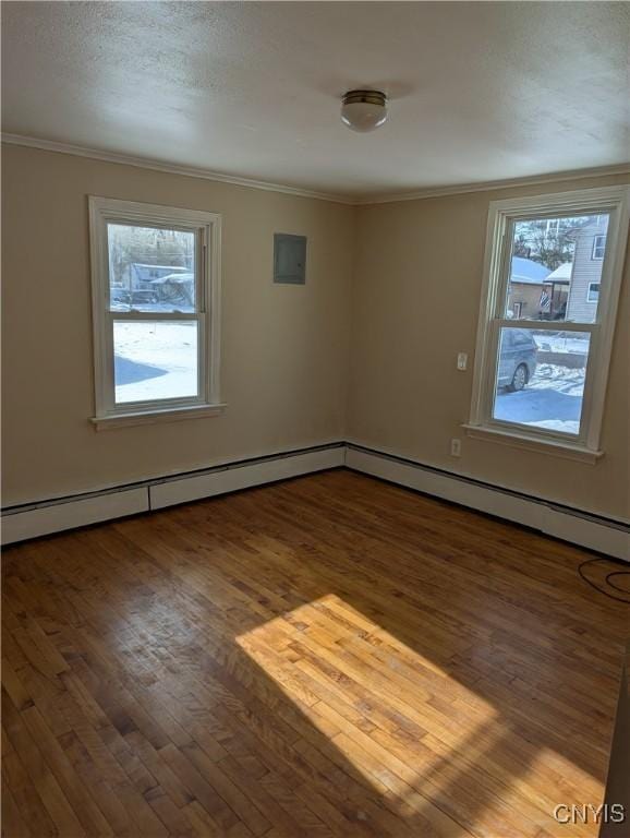 empty room with hardwood / wood-style floors, a textured ceiling, and ornamental molding