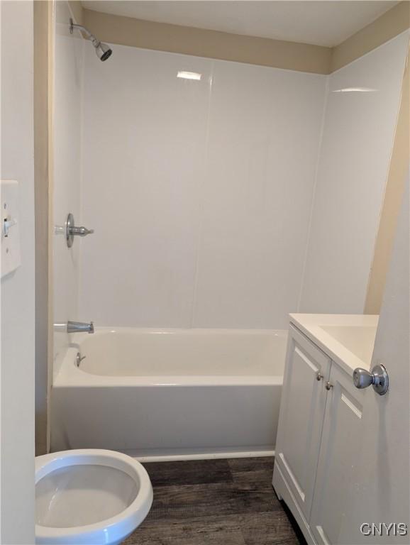 full bathroom with hardwood / wood-style floors, vanity, toilet, and bathing tub / shower combination