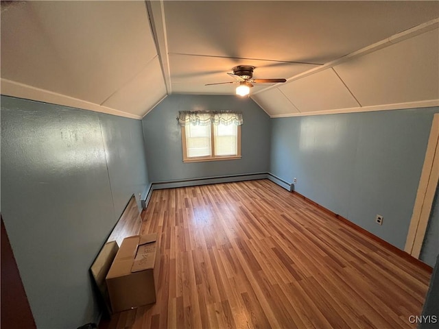 additional living space featuring hardwood / wood-style flooring, ceiling fan, baseboard heating, and vaulted ceiling