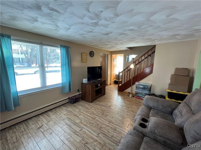 living room with baseboard heating and light hardwood / wood-style flooring